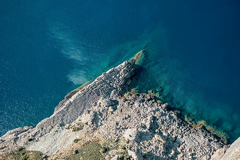 Rotsige kaap aan de westkust van Mallorca van bovenaf, met diepblauwe zee